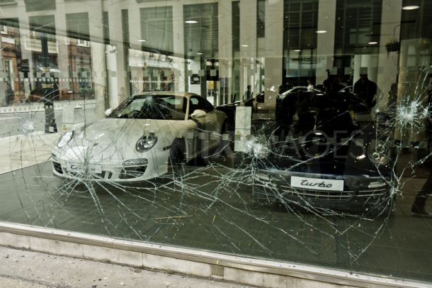 Broken glass in front of two sports cars