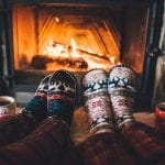 feet in cosy socks in front of a roaring fire